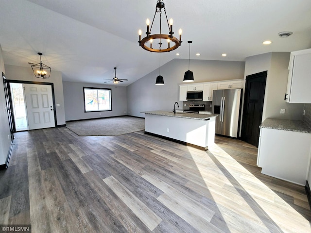 kitchen with vaulted ceiling, a sink, open floor plan, appliances with stainless steel finishes, and visible vents