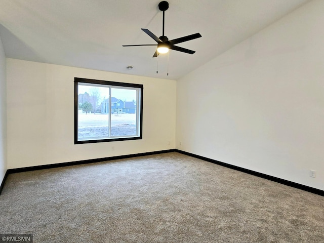 spare room featuring lofted ceiling, baseboards, carpet flooring, and ceiling fan