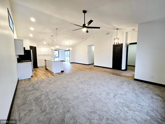 unfurnished living room with recessed lighting, light wood finished floors, vaulted ceiling, baseboards, and ceiling fan with notable chandelier