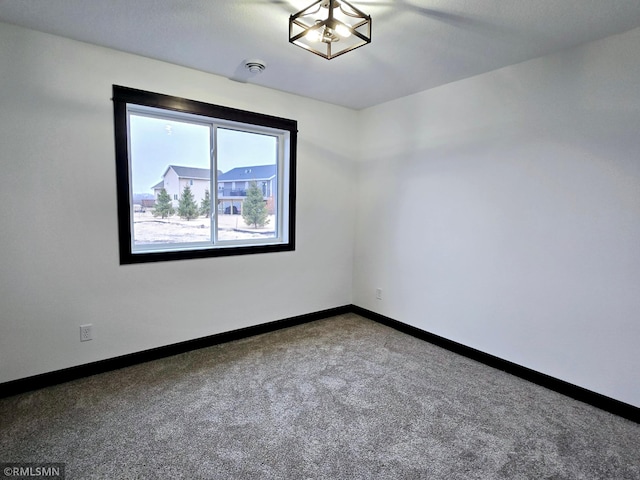 unfurnished room featuring carpet floors and baseboards