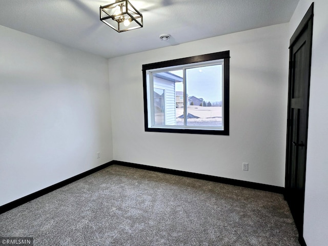 spare room featuring baseboards and carpet