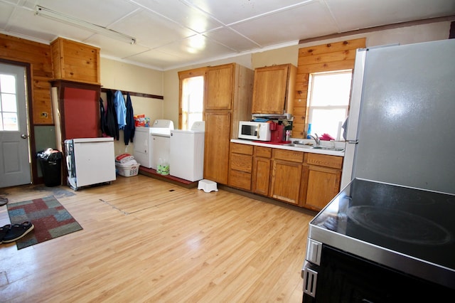 23585 Cross Dr, Deerwood, MN 56444 - kitchen with washing machine and clothes dryer, freestanding refrigerator, white microwave, electric range oven, and brown cabinetry