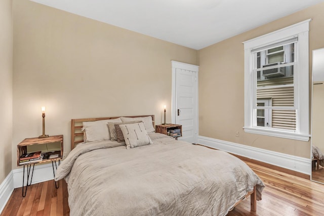 bedroom featuring baseboards and hardwood / wood-style flooring