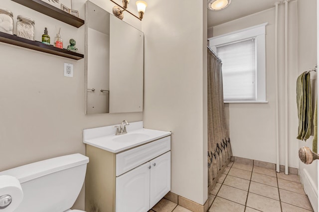 bathroom featuring vanity, toilet, baseboards, a shower with shower curtain, and tile patterned floors