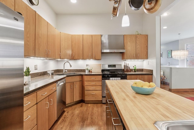231 Arundel St Unit 1, Saint Paul, MN 55102 - kitchen with stainless steel appliances, wall chimney exhaust hood, light wood-style flooring, butcher block counters, and recessed lighting