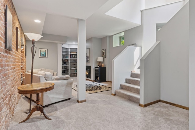 231 Arundel St Unit 1, Saint Paul, MN 55102 - carpeted living room with a glass covered fireplace, stairway, brick wall, recessed lighting, and built in shelves