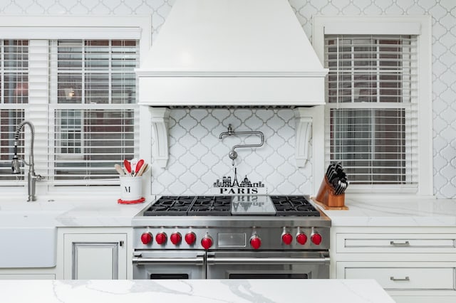 818 Summit Ave, Saint Paul, MN 55105 - kitchen with range with two ovens, custom exhaust hood, backsplash, and light stone countertops