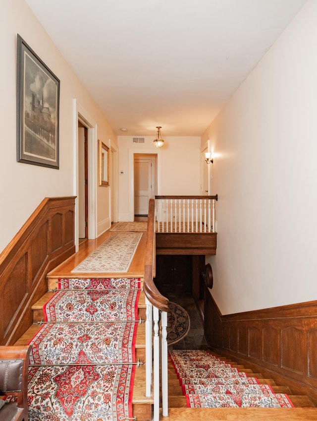 818 Summit Ave, Saint Paul, MN 55105 - stairway with wood finished floors and a wainscoted wall