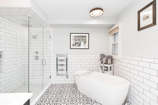 818 Summit Ave, Saint Paul, MN 55105 - full bath with tile walls, a soaking tub, a shower stall, a wainscoted wall, and tile patterned flooring