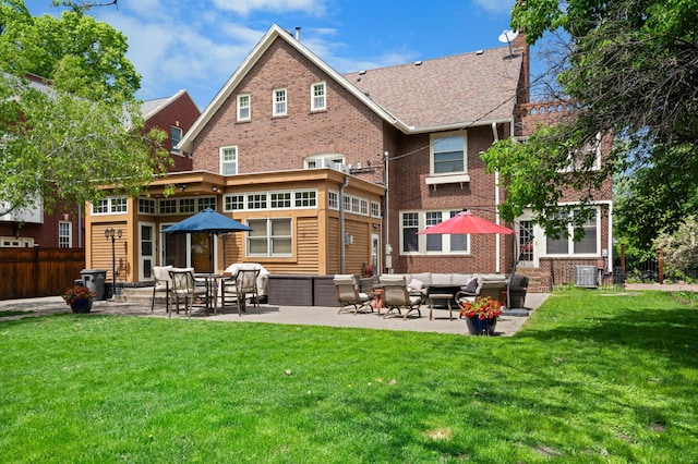 818 Summit Ave, Saint Paul, MN 55105 - back of house with an outdoor living space, a patio, brick siding, and a lawn