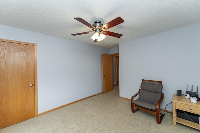 living area featuring a ceiling fan, baseboards, and carpet floors