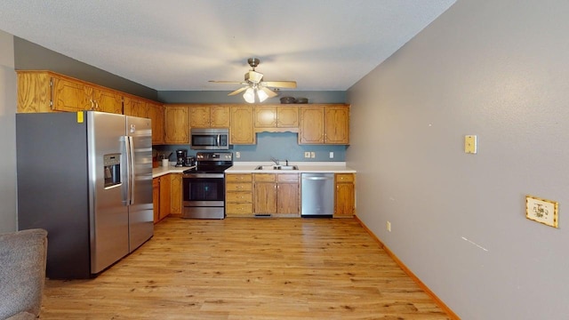 14190 Pineview Dr, Becker, MN 55308 - kitchen featuring appliances with stainless steel finishes, light wood-style flooring, light countertops, a ceiling fan, and brown cabinets