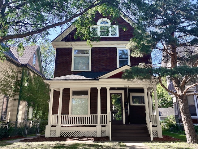 1605 Dupont Ave N, Minneapolis, MN 55411 - view of front facade featuring brick siding, fence, and covered porch