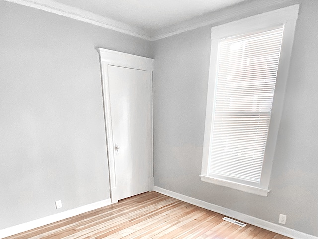 1605 Dupont Ave N, Minneapolis, MN 55411 - unfurnished room featuring light wood-style flooring, visible vents, crown molding, and baseboards