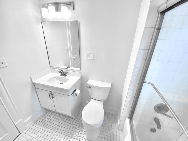 1605 Dupont Ave N, Minneapolis, MN 55411 - full bath featuring tile patterned flooring, combined bath / shower with glass door, toilet, vanity, and baseboards