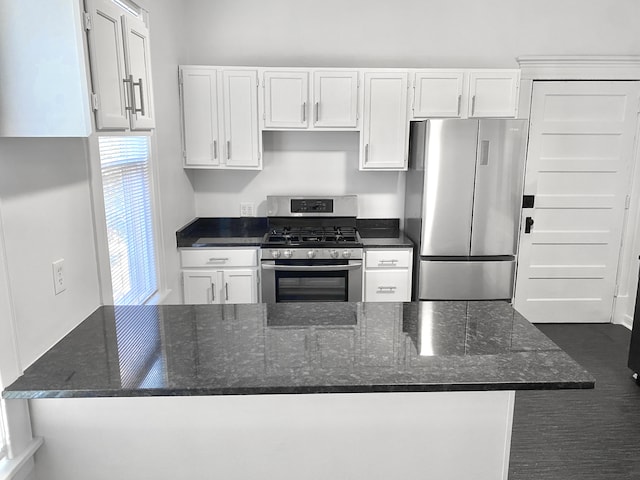 1605 Dupont Ave N, Minneapolis, MN 55411 - kitchen featuring a peninsula, appliances with stainless steel finishes, white cabinetry, and dark stone countertops