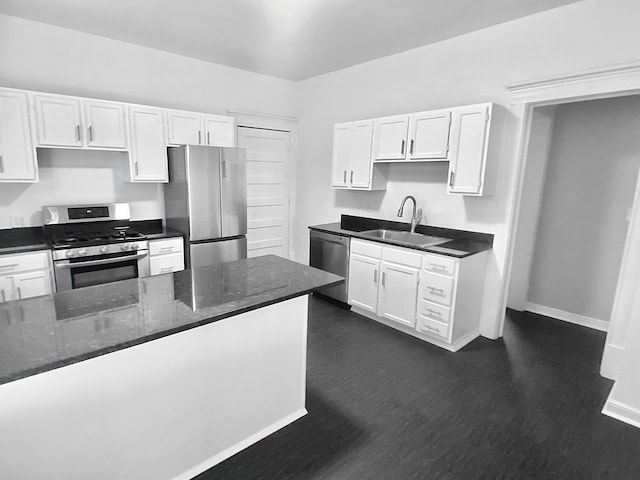 1605 Dupont Ave N, Minneapolis, MN 55411 - kitchen featuring appliances with stainless steel finishes, baseboards, white cabinetry, and a sink