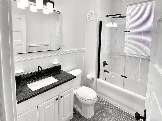 1605 Dupont Ave N, Minneapolis, MN 55411 - bathroom featuring toilet, tile walls, wainscoting, tile patterned flooring, and vanity