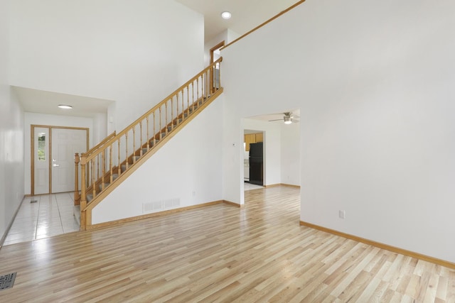 8722 Norway St NW, Coon Rapids, MN 55433 - unfurnished living room featuring stairway, wood finished floors, a high ceiling, baseboards, and recessed lighting