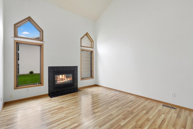 8722 Norway St NW, Coon Rapids, MN 55433 - unfurnished living room with light wood-style floors, a fireplace, baseboards, and high vaulted ceiling