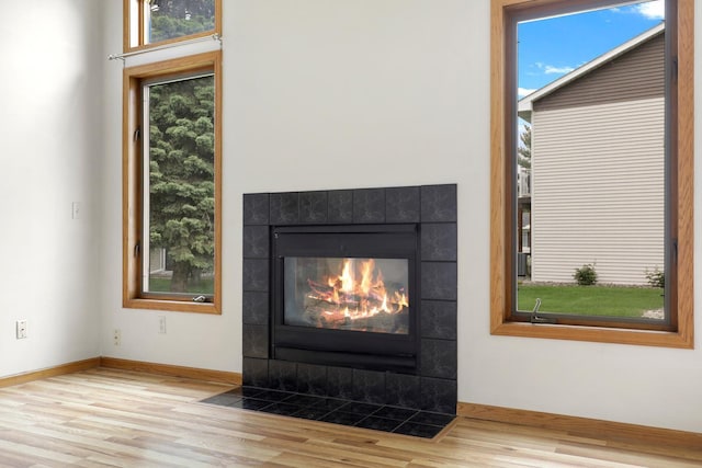 8722 Norway St NW, Coon Rapids, MN 55433 - detailed view of wood finished floors, a tiled fireplace, and baseboards
