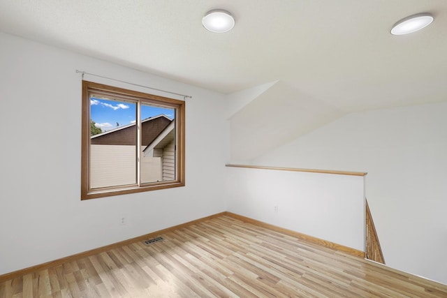 8722 Norway St NW, Coon Rapids, MN 55433 - empty room with light wood-style flooring, baseboards, and vaulted ceiling