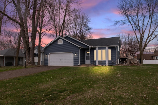 ranch-style home with a lawn, fence, dirt driveway, and an attached garage