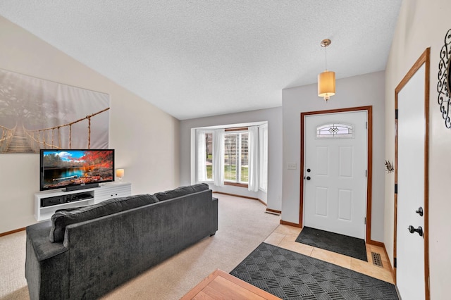 foyer with baseboards, visible vents, light carpet, and a textured ceiling