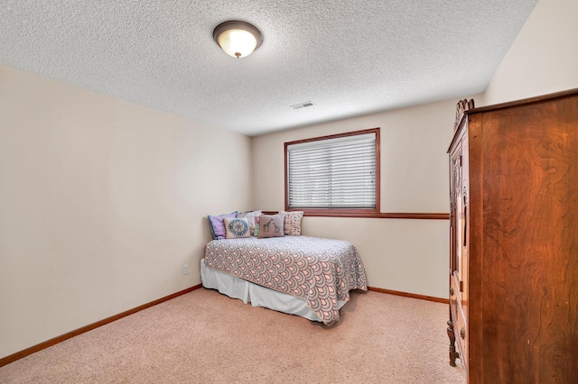 bedroom with a textured ceiling, visible vents, and carpet floors