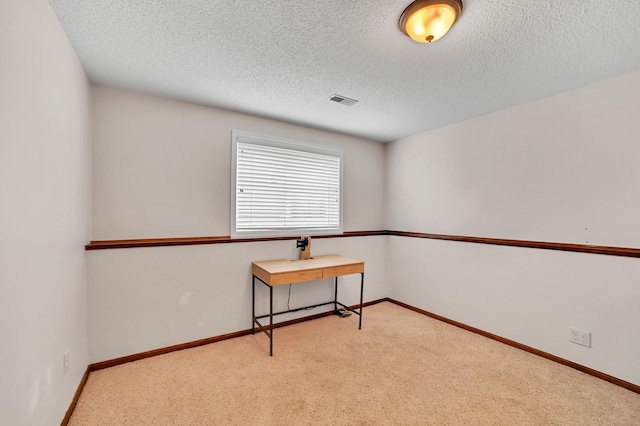 carpeted empty room with a textured ceiling, visible vents, and baseboards