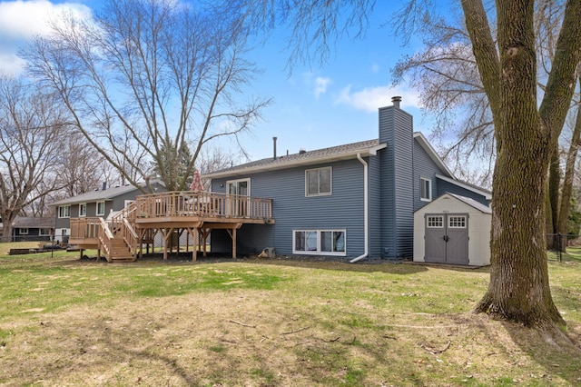 back of property featuring a chimney, a lawn, a wooden deck, a shed, and stairs