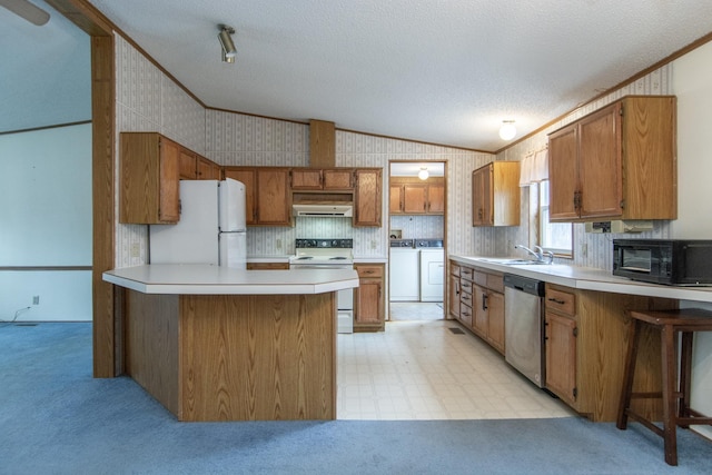 kitchen featuring extractor fan, white appliances, washer and clothes dryer, and brown cabinets