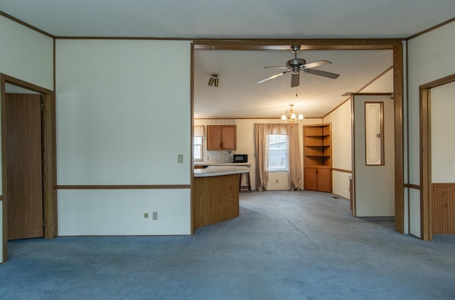 unfurnished living room featuring light colored carpet, lofted ceiling, and ceiling fan with notable chandelier