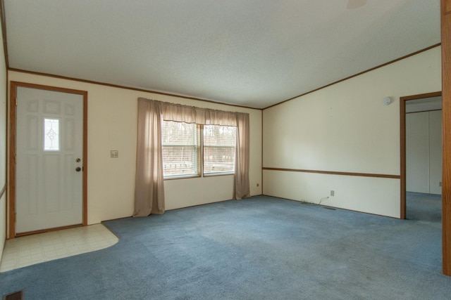 carpeted foyer with ornamental molding