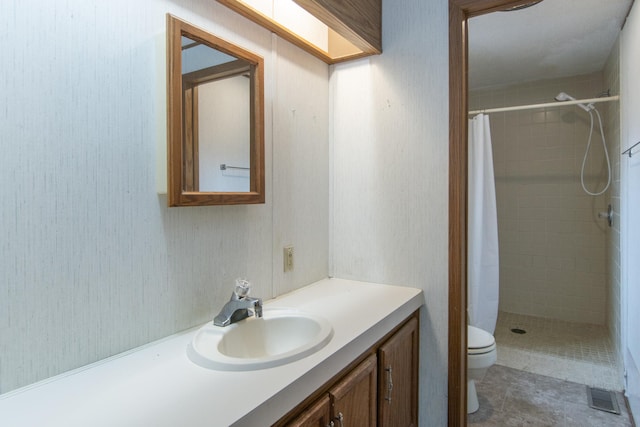 bathroom with a stall shower, visible vents, vanity, and toilet