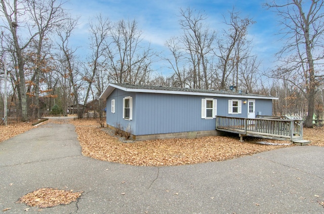 manufactured / mobile home featuring a shingled roof, crawl space, aphalt driveway, and a deck