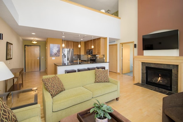 240 Spring St Unit 331, Saint Paul, MN 55102 - living area with visible vents, a high ceiling, light wood-type flooring, recessed lighting, and a tile fireplace