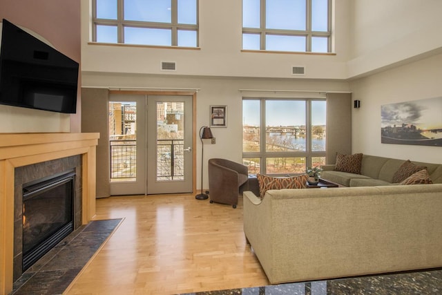 240 Spring St Unit 331, Saint Paul, MN 55102 - living area with a towering ceiling, a tiled fireplace, visible vents, a water view, and wood finished floors