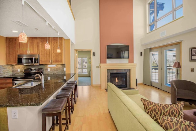 240 Spring St Unit 331, Saint Paul, MN 55102 - kitchen with visible vents, appliances with stainless steel finishes, light wood-style floors, brown cabinetry, and rail lighting