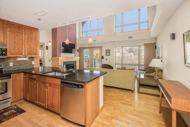 240 Spring St Unit 331, Saint Paul, MN 55102 - kitchen featuring light wood-style floors, a peninsula, a sink, stainless steel appliances, and open floor plan