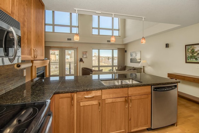 240 Spring St Unit 331, Saint Paul, MN 55102 - kitchen with light wood-style flooring, appliances with stainless steel finishes, a sink, open floor plan, and decorative backsplash