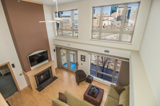 240 Spring St Unit 331, Saint Paul, MN 55102 - living room featuring visible vents, wood finished floors, a towering ceiling, and a fireplace with flush hearth