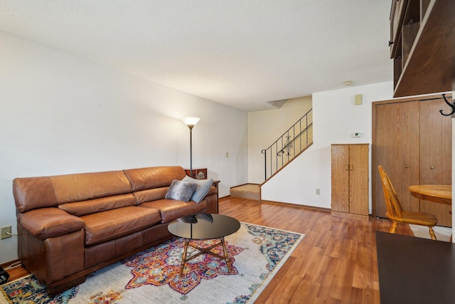 living room with stairway and wood finished floors