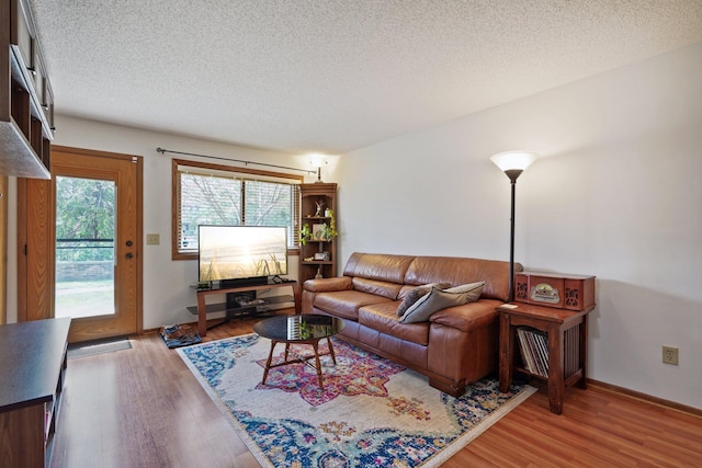 living area featuring light wood-type flooring and a textured ceiling