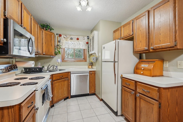kitchen featuring brown cabinets, appliances with stainless steel finishes, and a sink