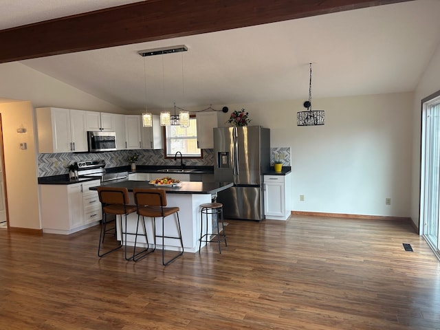 kitchen featuring lofted ceiling with beams, a sink, tasteful backsplash, a notable chandelier, and appliances with stainless steel finishes