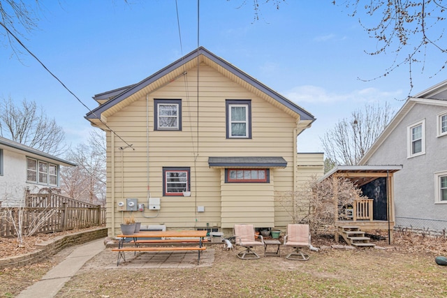 rear view of house featuring fence and a patio