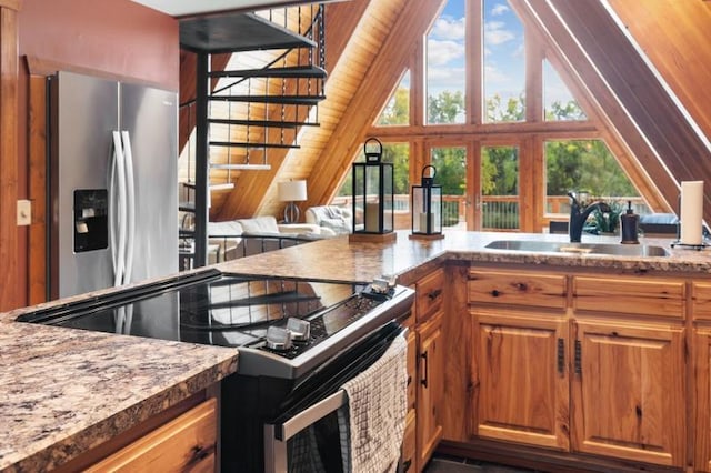 kitchen featuring stainless steel fridge, a sink, electric stove, brown cabinets, and vaulted ceiling