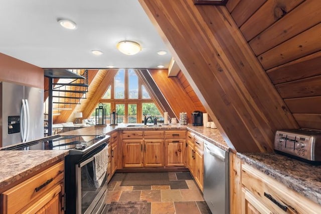 kitchen featuring stainless steel appliances, a toaster, stone finish floor, and a sink