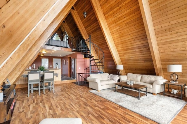living area featuring wood walls, beam ceiling, and wood finished floors